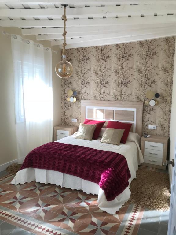 アレーナス・デ・サン・ペドロにあるCharcos de Gredosのベッドルーム(紫の毛布を使用した大型ベッド1台付)