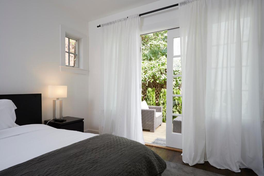 um quarto com uma cama e uma porta de vidro deslizante em Station Inn Pawling em Pawling