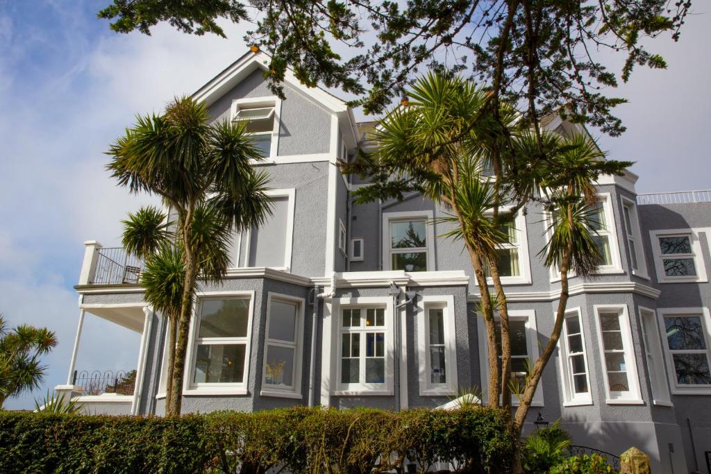 a white house with palm trees in front of it at The Lerryn in Falmouth