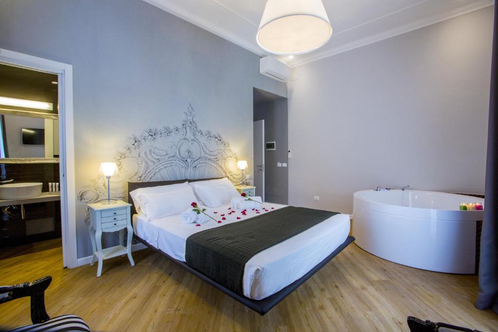 1 dormitorio con 1 cama grande y bañera en Ara Suite, en Roma