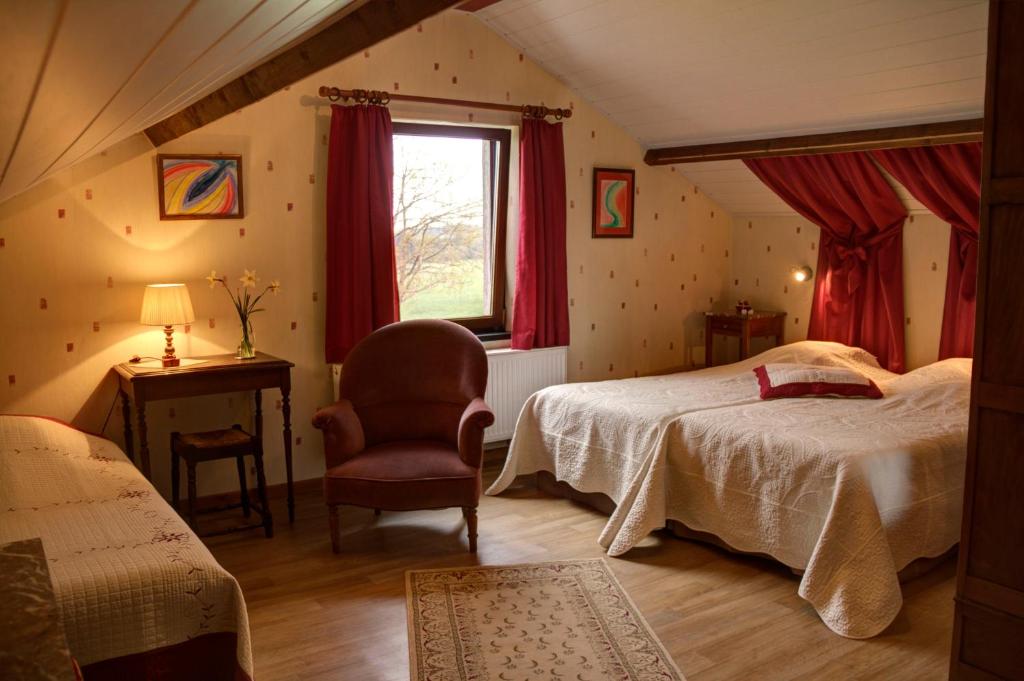 1 dormitorio con 2 camas, silla y ventana en B&B Sol Magnus, en Stavelot