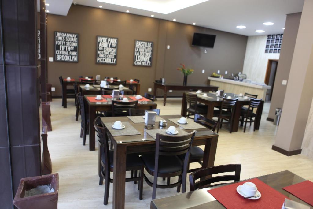 a dining room with tables and chairs in a restaurant at HOTEL ALVORADA in Leopoldina