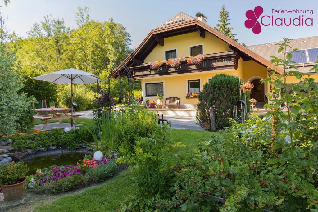 a garden in front of a house with an umbrella at Ferienwohnung Claudia in Faistenau