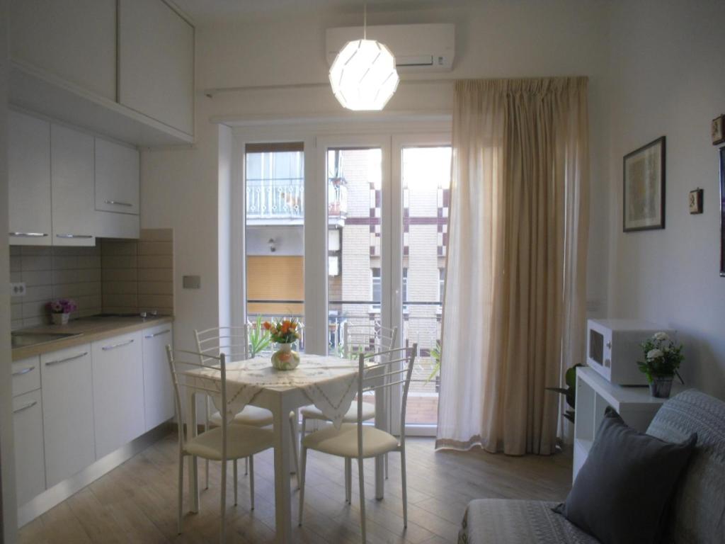 een keuken en eetkamer met een tafel en stoelen bij Lovely Little Apartment in Via Aurelia in Rome