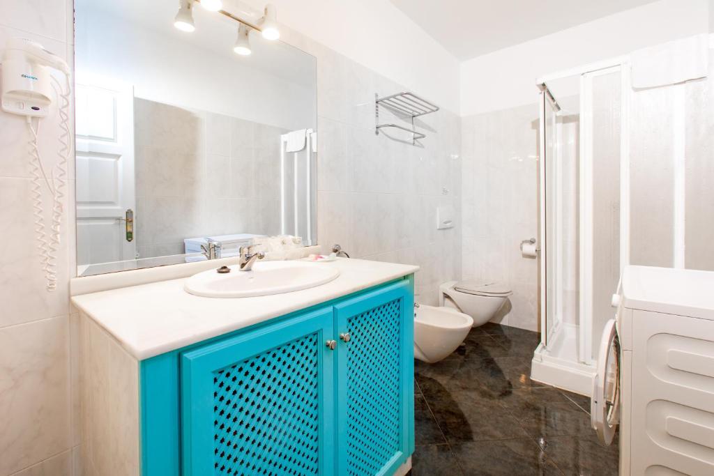 a bathroom with a blue sink and a toilet at AT Almoraide Rooms Suites in Nerja