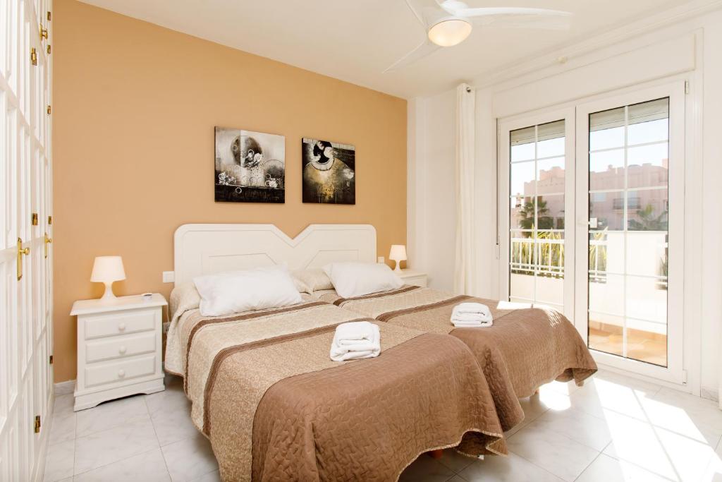 a bedroom with a large bed and a window at AT Almoraide Rooms Suites in Nerja