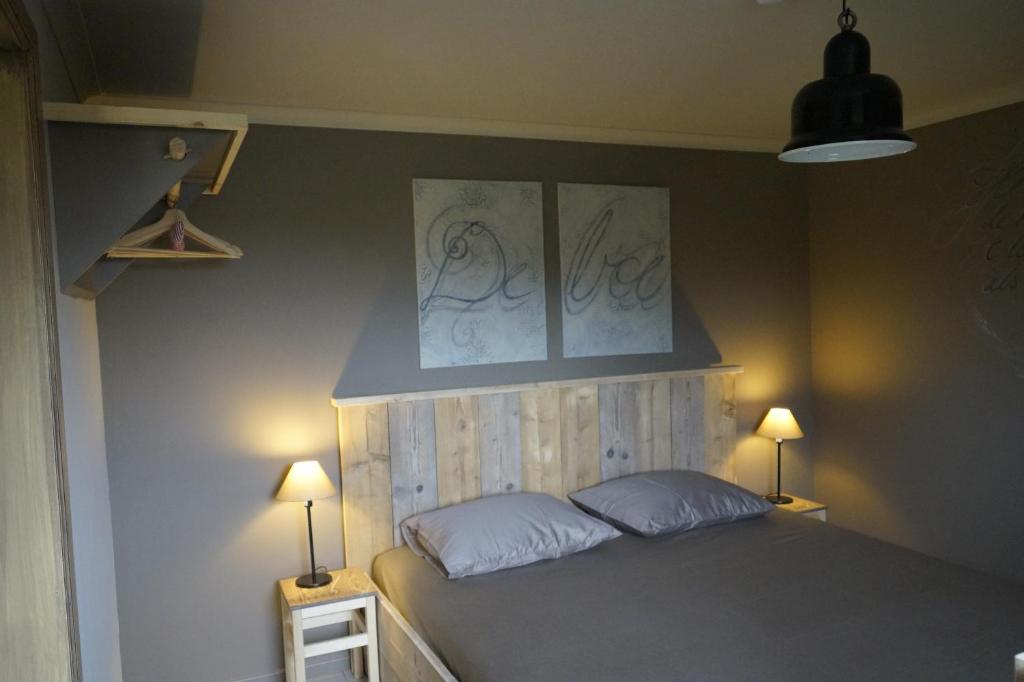 een slaapkamer met een bed met 2 kussens en 2 lampen bij Kampenhof in Maaseik