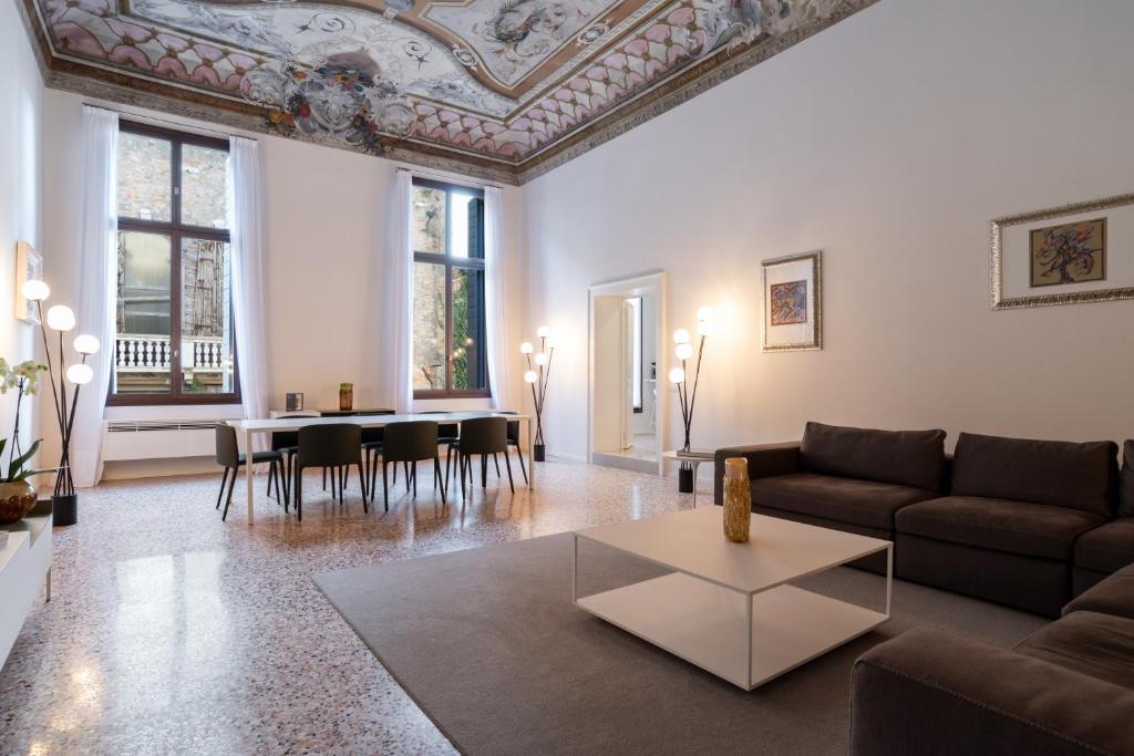 a living room filled with furniture and a large window at Palazzo Vendramin Costa in Venice