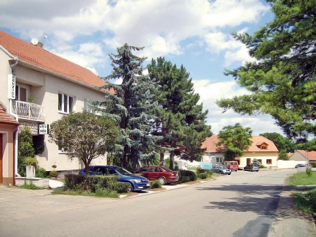 a street with cars parked on the side of a house at ABEN & HANA penzion in Modřice