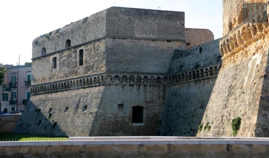 ein großes Backsteingebäude mit einer Wand in der Unterkunft DIMORA CAVALLERIZZA in Bari