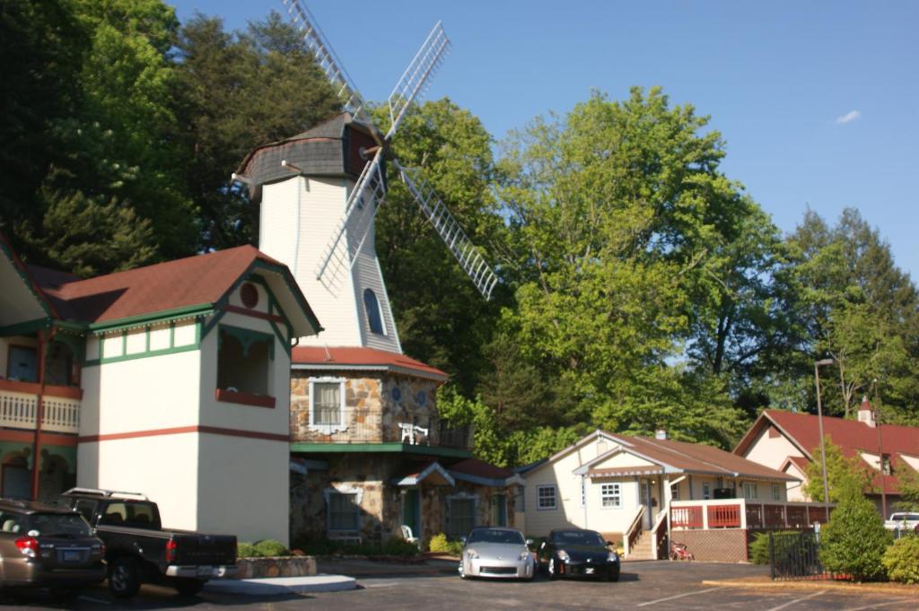 un molino de viento frente a una casa con coches aparcados en Heidi Motel - Helen en Helen