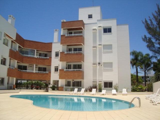 um edifício com piscina em frente a um edifício em Repouso Gaivotas em Florianópolis