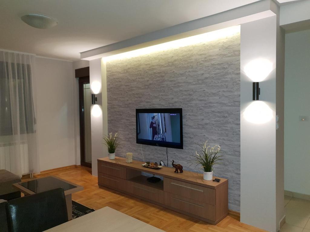 ズラティボールにあるApartman Aspenの石壁のリビングルーム(テレビ付)