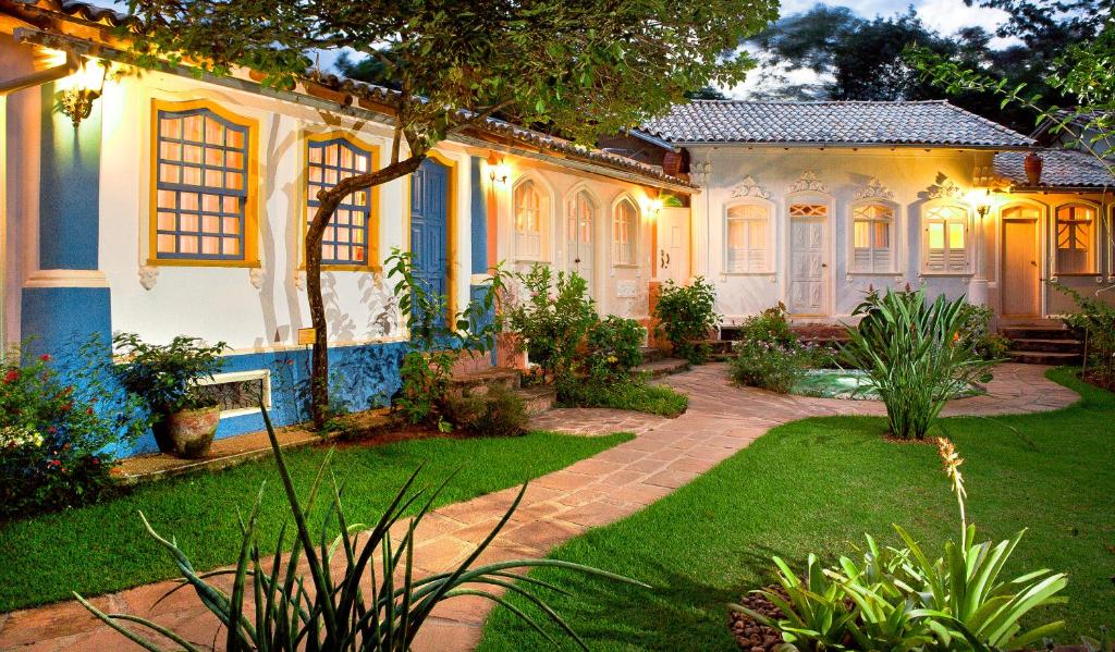 a house with a garden in front of it at Pousada Vila Serrano in Lençóis