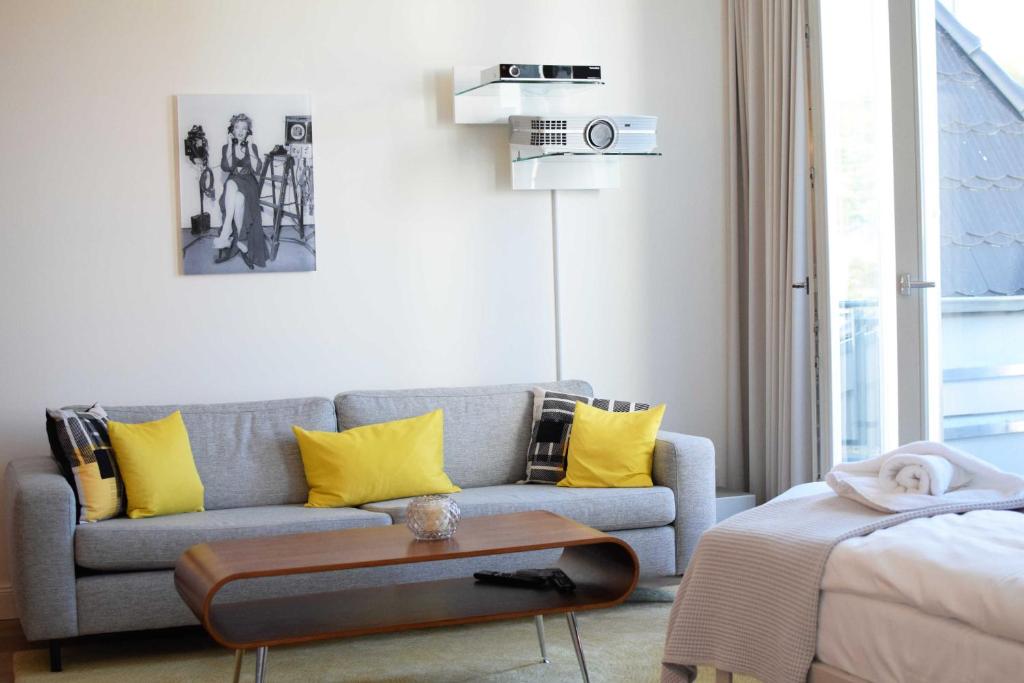 オストゼーバート・ゼリンにあるGalene FIRST SELLIN Appartement 40のリビングルーム(グレーのソファ、黄色の枕付)