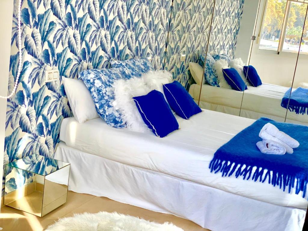 1 dormitorio con 2 camas y almohadas azules y blancas en Málaga Center Beach en Málaga