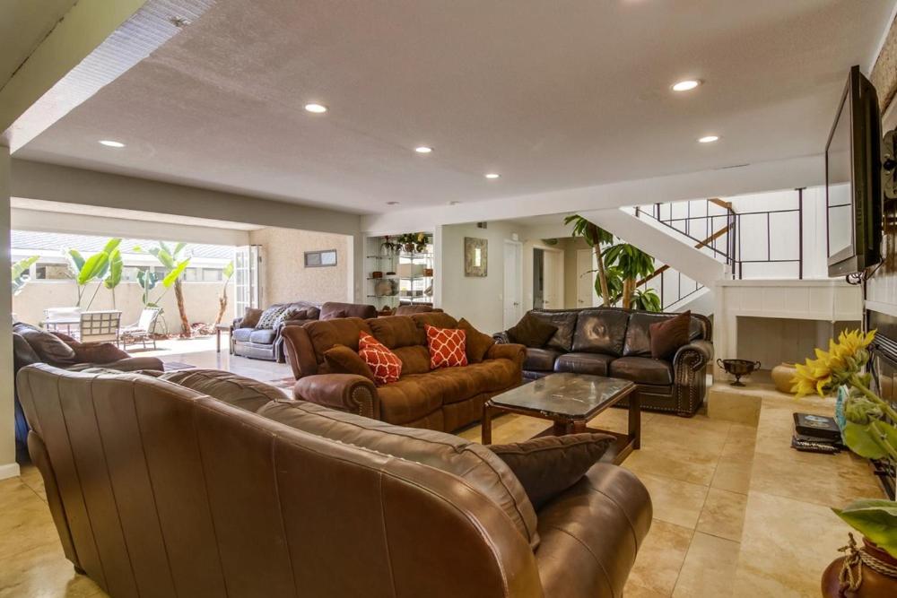 uma sala de estar com mobiliário de couro e uma escadaria em PACIFIC BEACH MANSION em San Diego