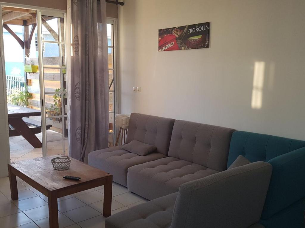 a living room with a couch and a table at CHIRIJIEN BLÉ in Le Robert