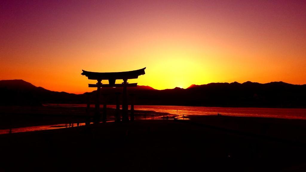 an asian gate in front of a sunset at Vacation stay Miyajima in Miyajima