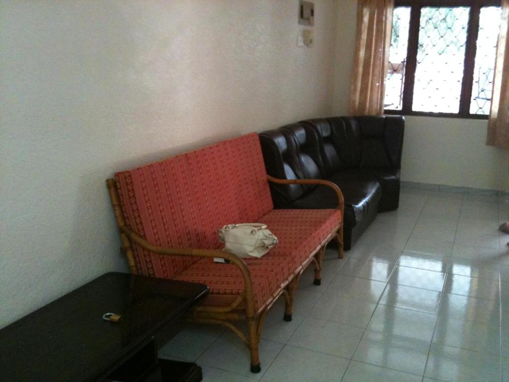 Yong Homestay في كوالا برليس: غرفة معيشة مع أريكة وكرسي