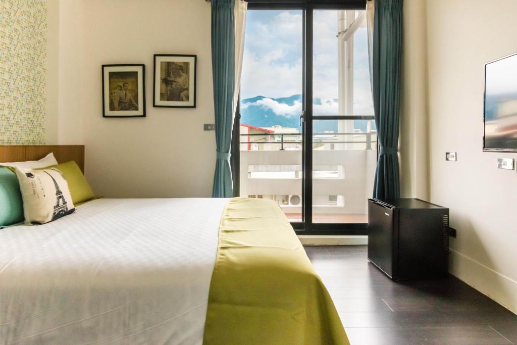 a bedroom with a large bed and a large window at 321 Apartment B&amp;B in Hualien City