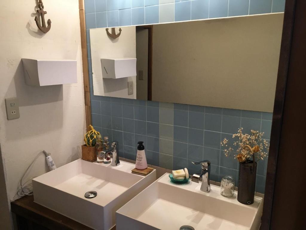 a bathroom with a white sink and a mirror at Guest House Minato in Miyako