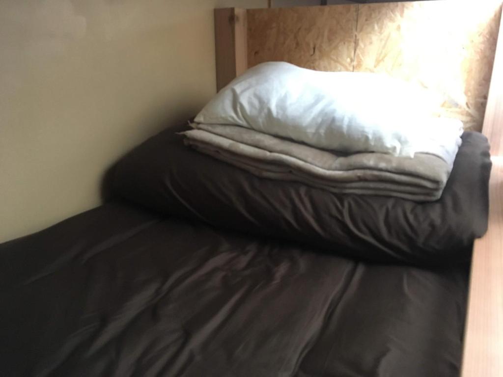 a bed with a white pillow on top of it at Guest House Minato in Miyako