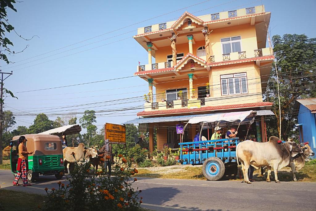 a cow pulling a cart in front of a building at Tiger Corner Inn Homestay in Sauraha