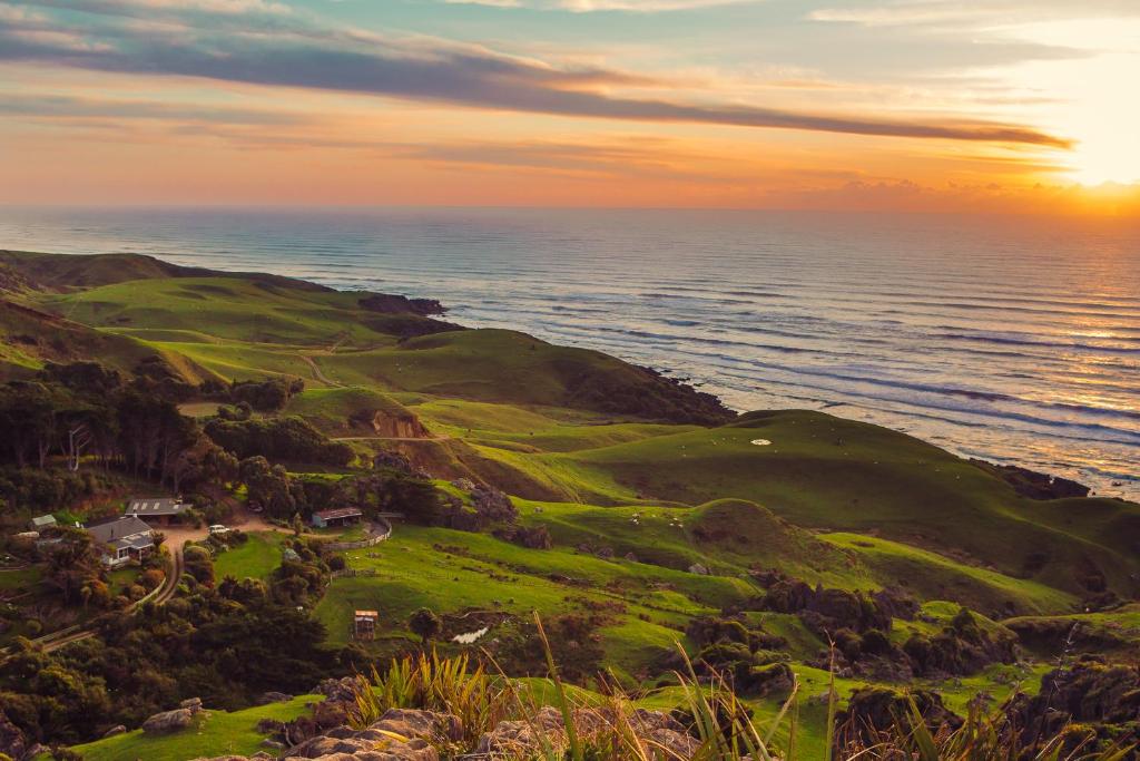 an aerial view of a golf course on the ocean at Te Hapu Coastal Cottages in Collingwood