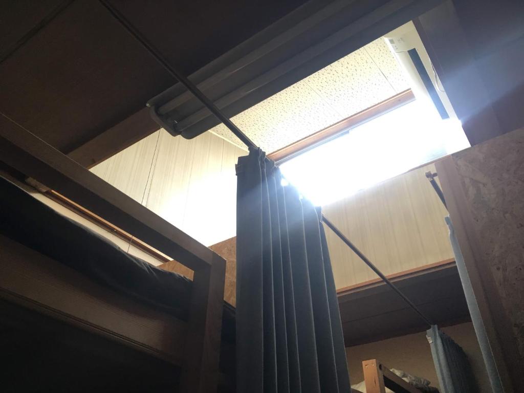 a window in a room with a curtain at Guest House Minato in Miyako