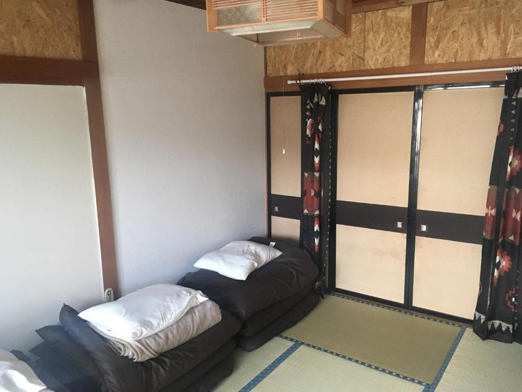 a small room with a couch and a window at Guest House Minato in Miyako