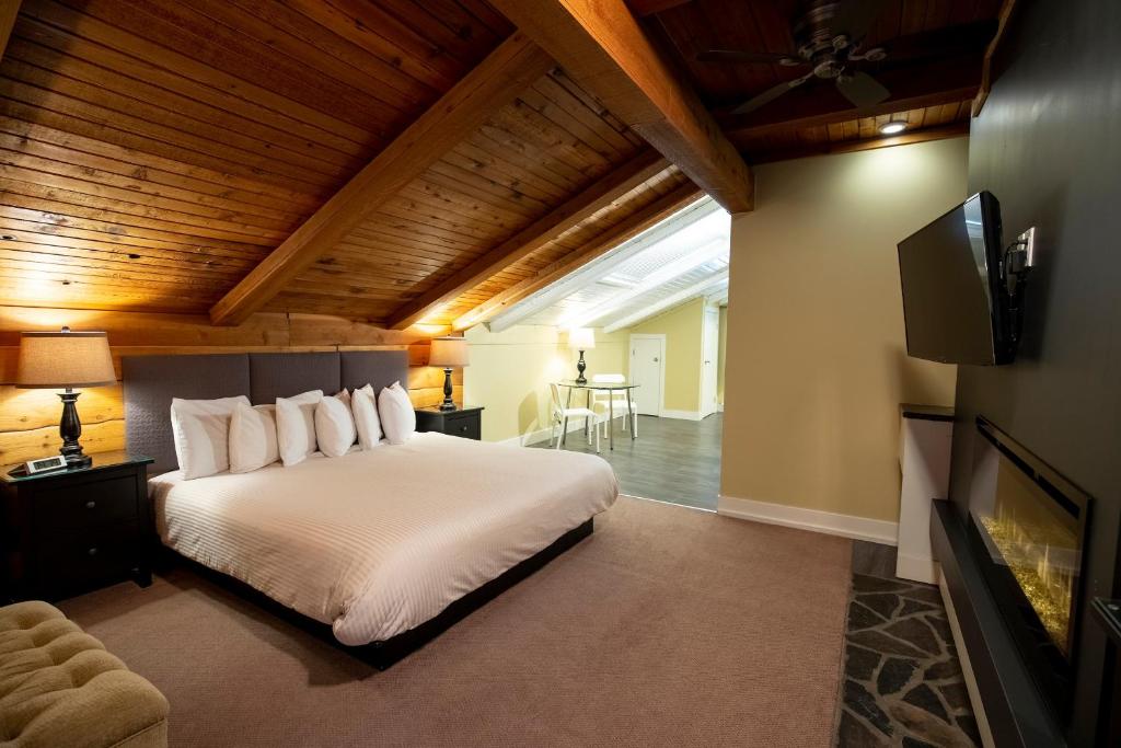 a bedroom with a large white bed and a tv at Banff Boutique Inn - Adults only in Banff