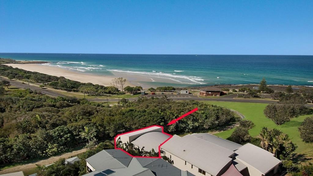 an aerial view of a beach with a building and the ocean at Surfside in East Ballina