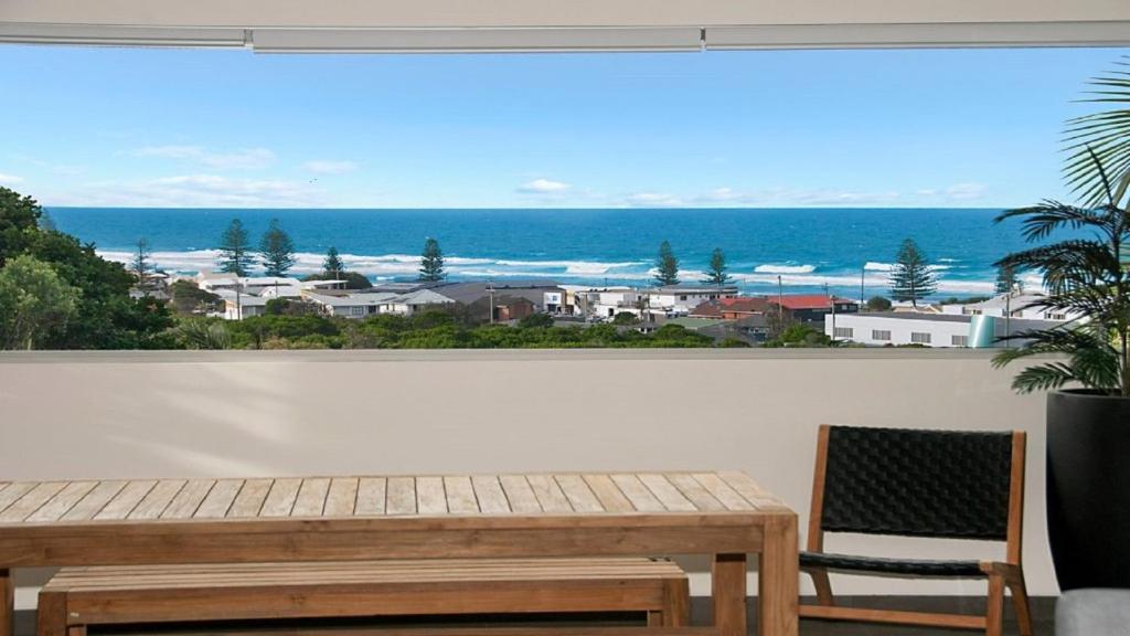 a window with a wooden bench and a view of the ocean at Vista in Lennox Head