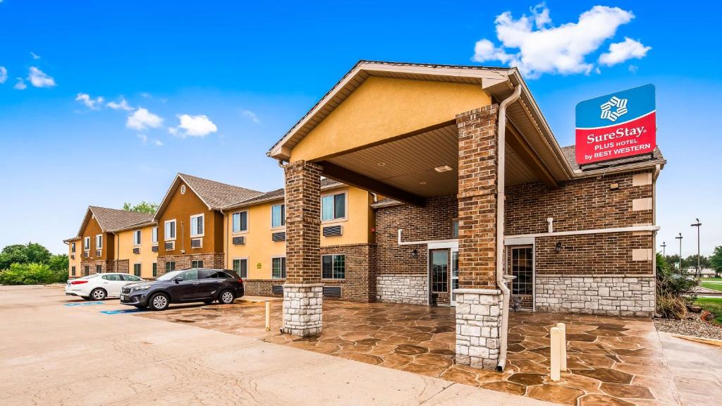 a building with a car parked in front of it at SureStay Plus Hotel by Best Western Kearney in Kearney