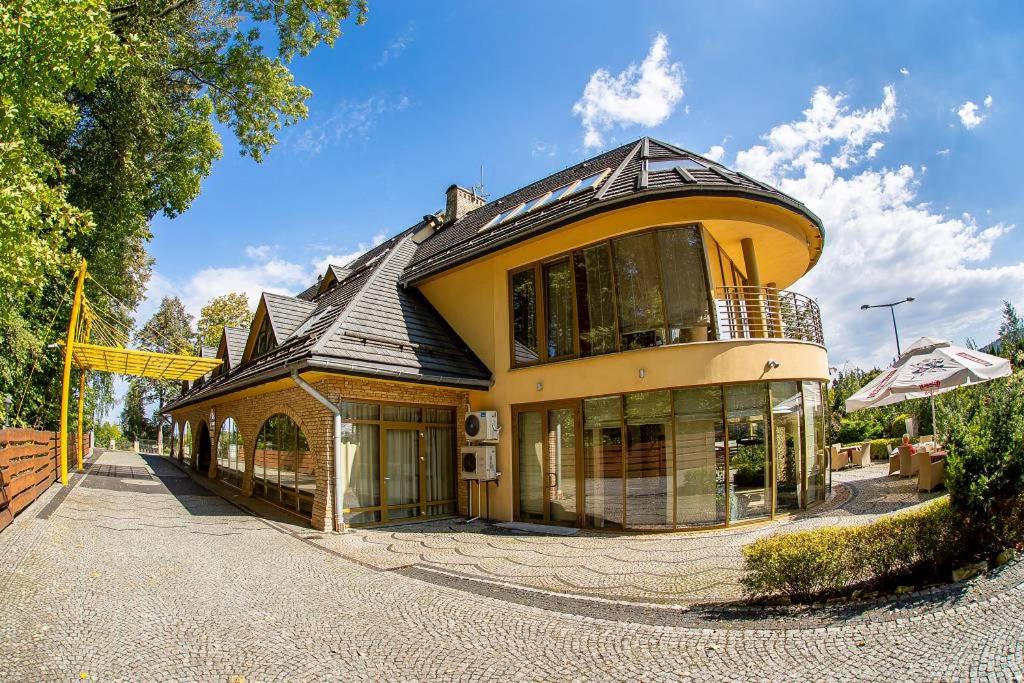 una gran casa amarilla con techo de gambrel en Hotel Sahara, en Bielsko-Biala