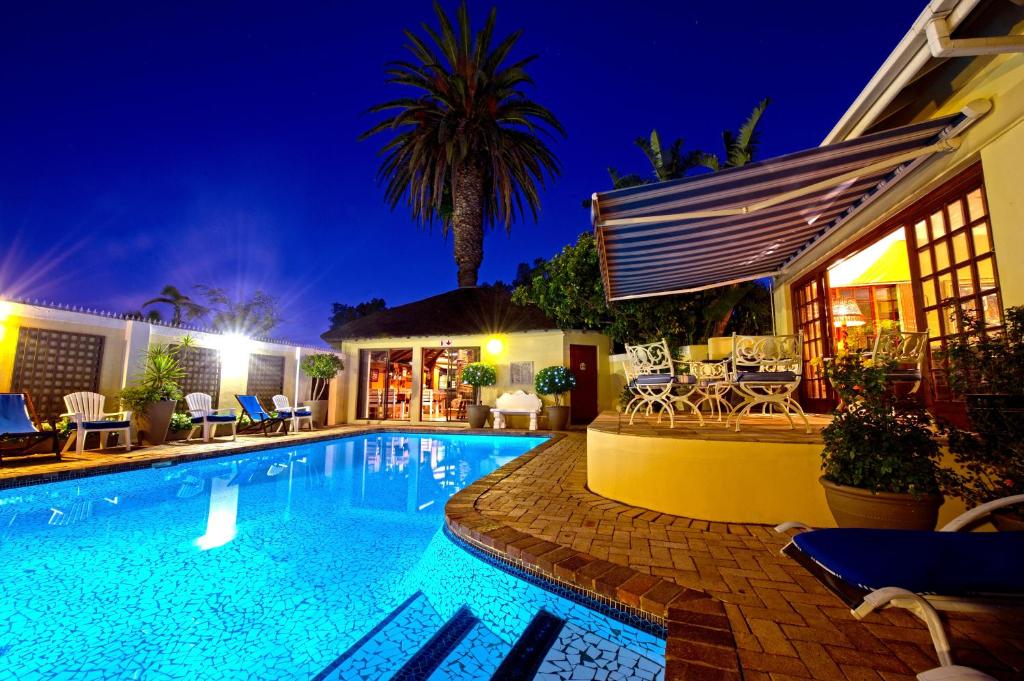 uma piscina em frente a uma casa à noite em Margate Place Guest House em Port Elizabeth