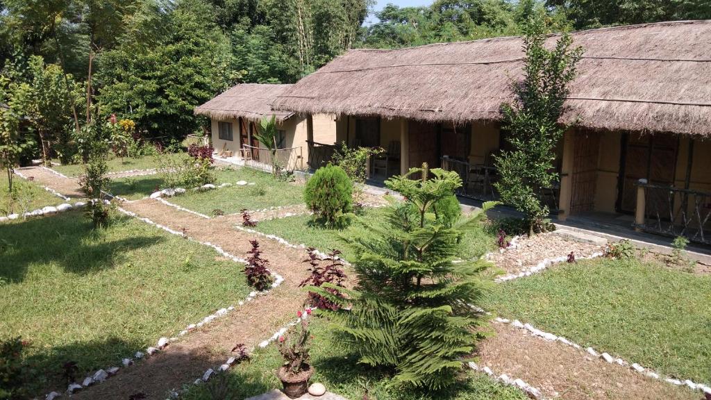 un jardín frente a una casa con un edificio en Chital lodge, en Chitwan