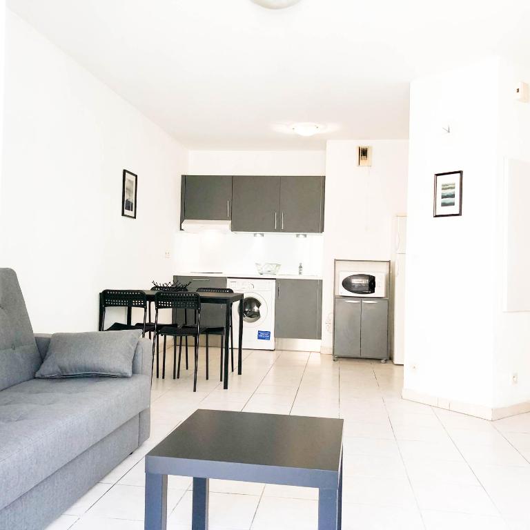 un salon avec un canapé et une table dans l'établissement Arson Riquier Port, à Nice