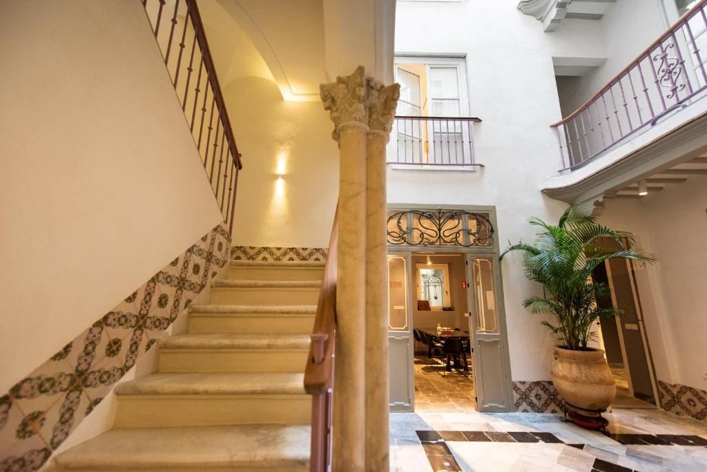 eine Treppe in einem Haus mit einer Säule in der Unterkunft La Casa del Consul in Cádiz