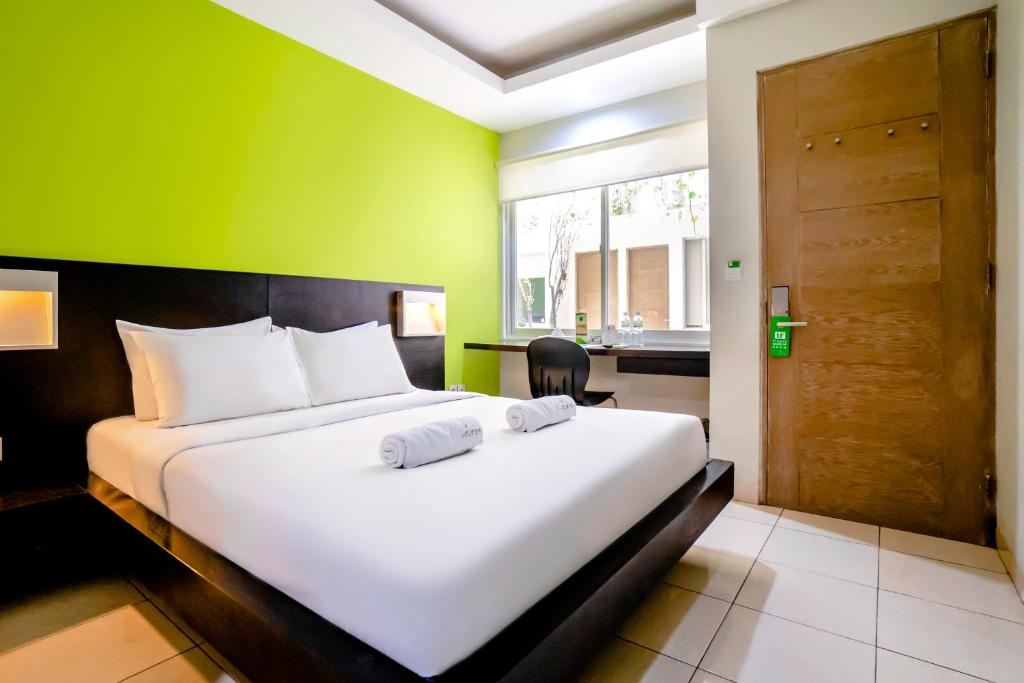 Postel nebo postele na pokoji v ubytování LeGreen Suite Tondano