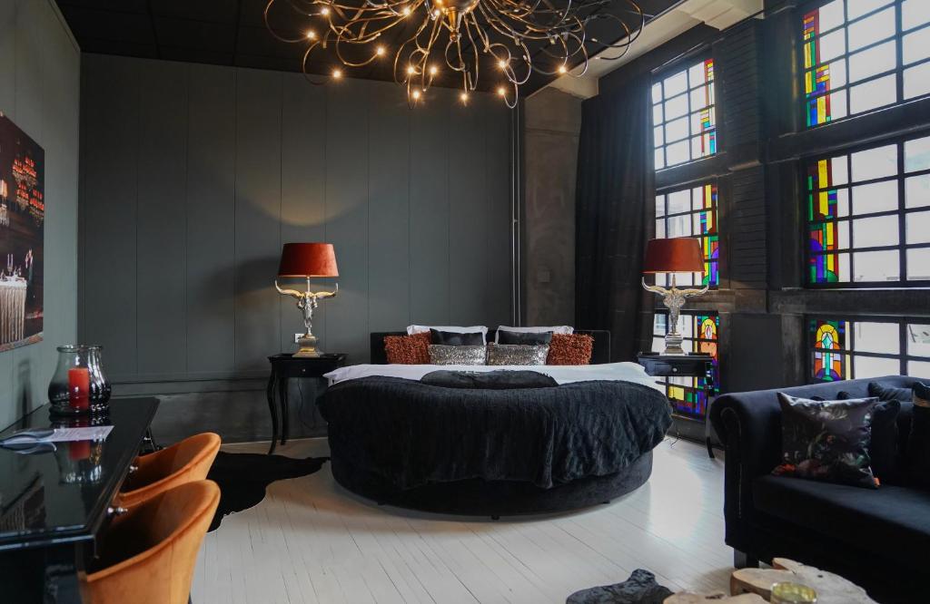 a bedroom with a large bed and a chandelier at Huis van Bewaring in Almelo
