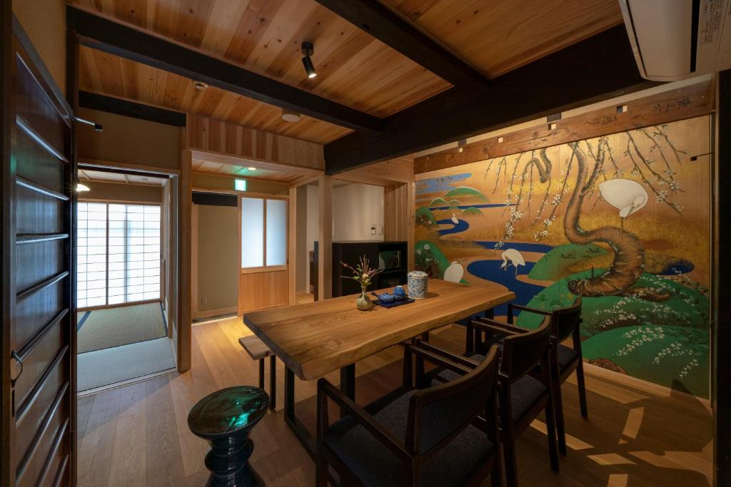 a dining room with a table and a painting on the wall at Gion Shirakawa Kouki Machiya House in Kyoto