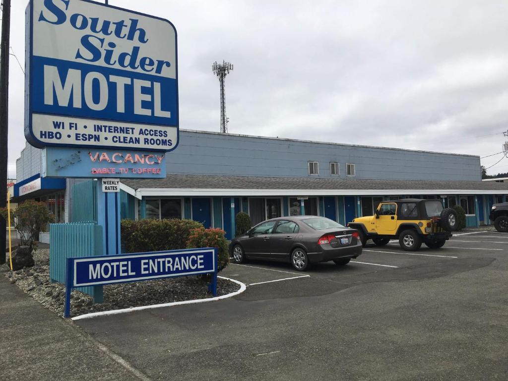 a motel with cars parked in a parking lot at Southsider Motel in Coos Bay