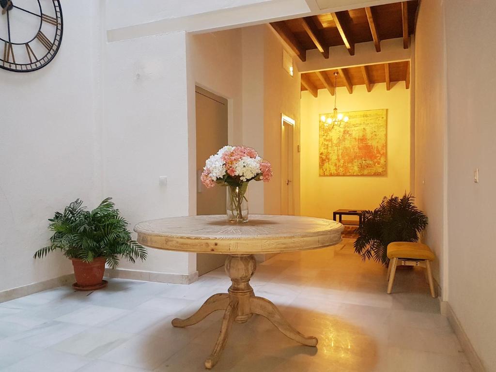 stół z wazonem kwiatów w pokoju w obiekcie Casas de Sevilla - Casa Sevillana Harinas26 w Sewilli