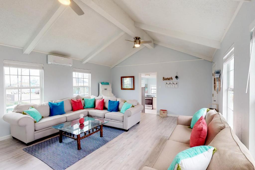 a living room with two couches and a table at Midtown Paradise on the Beach in Galveston