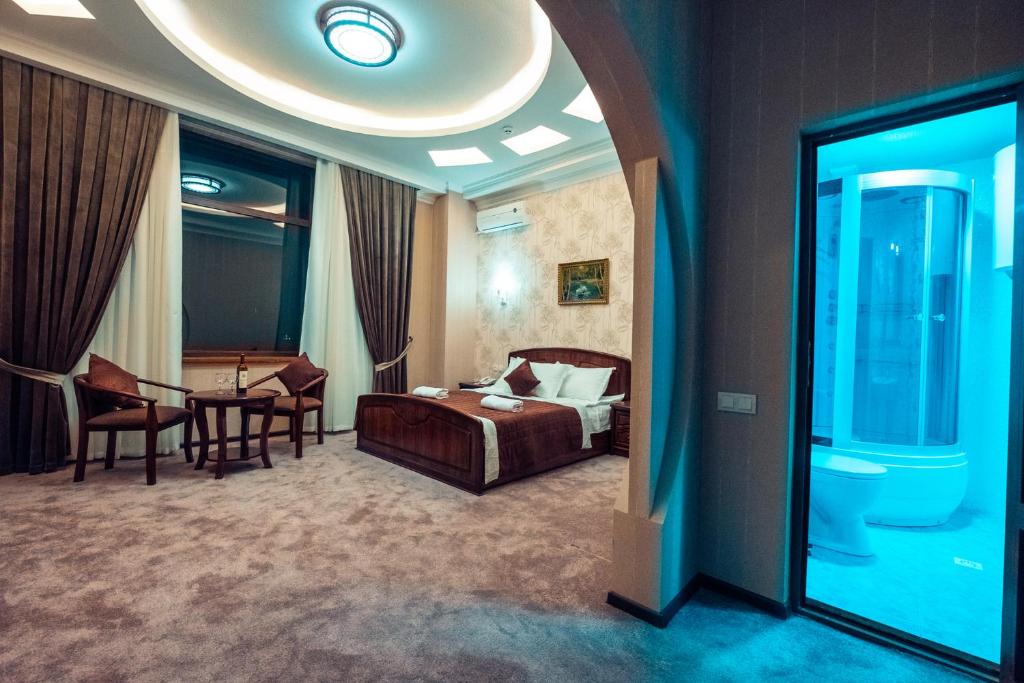 a hotel room with a bed and a table and chairs at Meros Boutique Hotel in Samarkand
