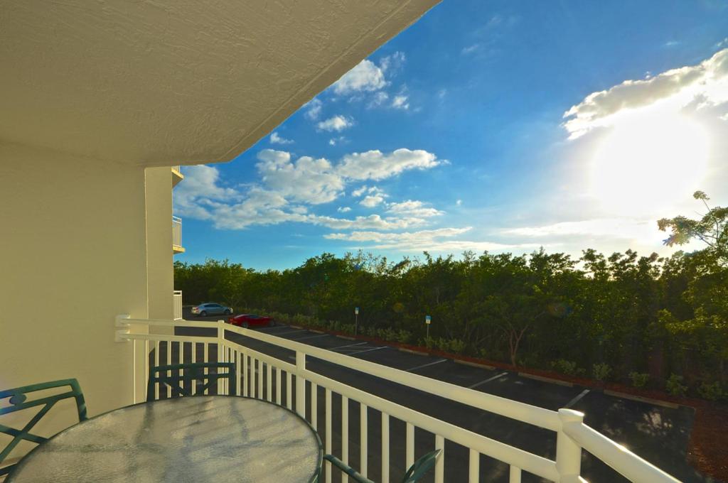 balcón con mesa y vistas a la calle en Sunrise Suites Dominican Suite #110, en Key West