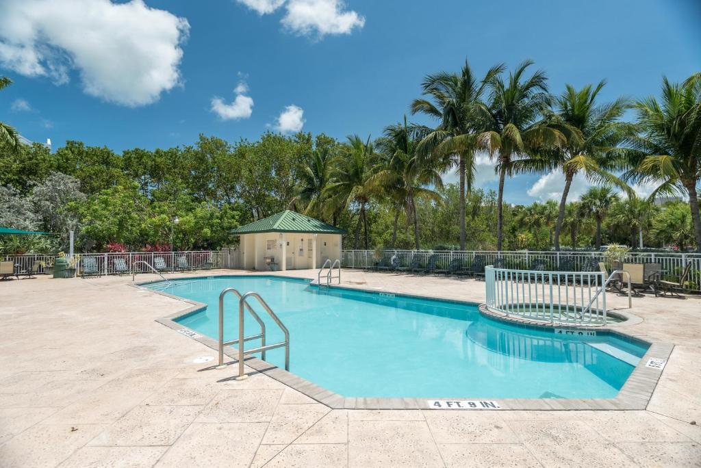 einen Pool in einem Resort mit Palmen im Hintergrund in der Unterkunft Sunrise Suites Panama Suite #310 in Key West