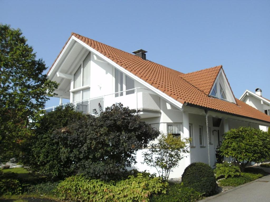 una casa blanca con techo naranja en Haus Obere Weinburg, en Radolfzell am Bodensee